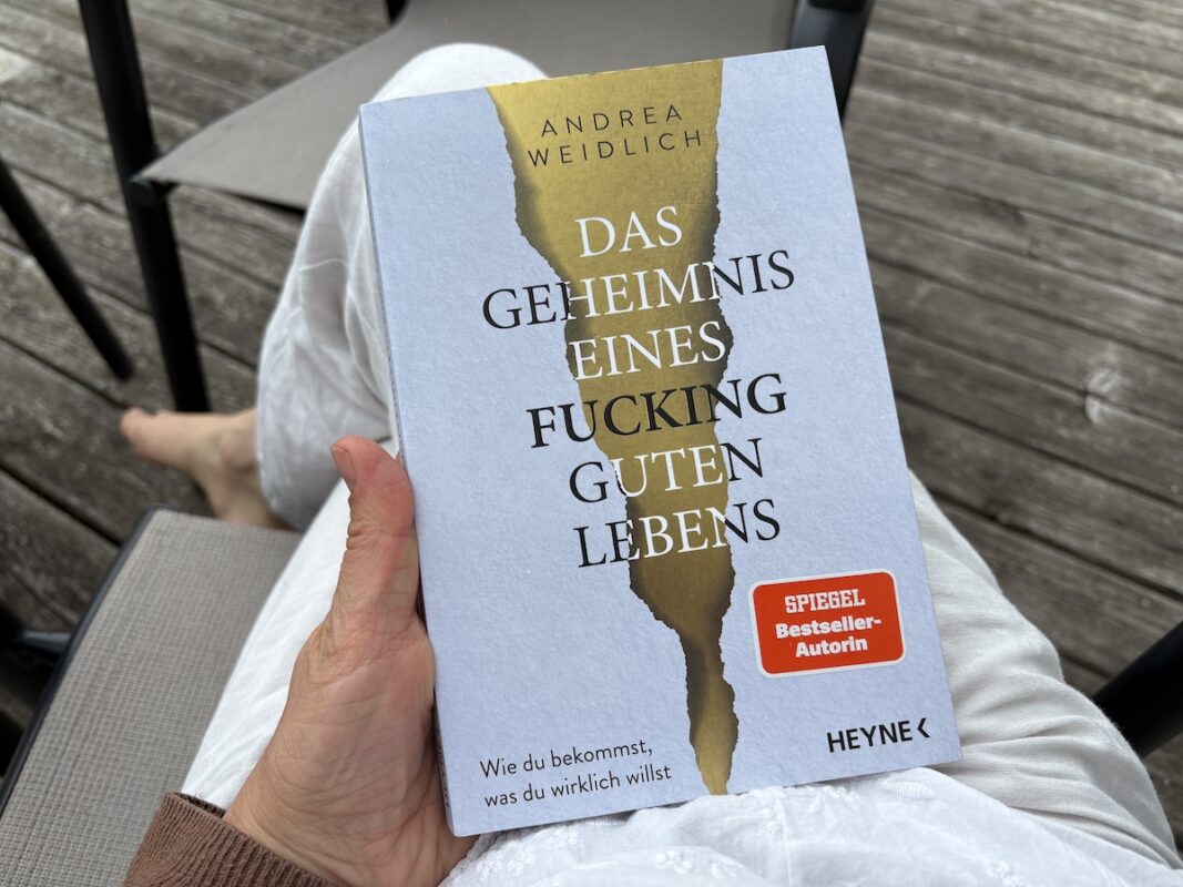 das geheimnis eines fucking guten lebens - buch in meiner hand auf dem schoß