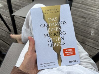das geheimnis eines fucking guten lebens - buch in meiner hand auf dem schoß